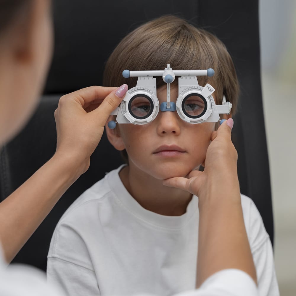 A young boy having his vision tested at a pediatric clinic, as a doctor uses a specialized tool for the eye examination.