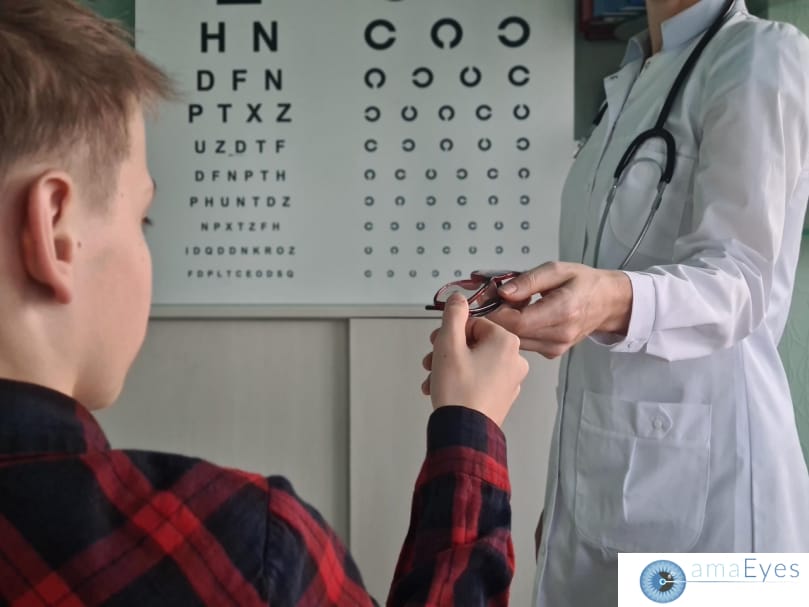 Child undergoing a vision test at a pediatric clinic, pointing at letters on an eye chart during the examination.